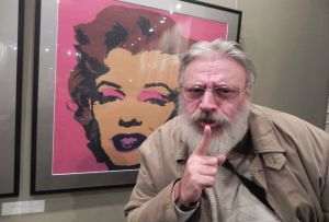 Duminică, m-am dus la Sala Mică a Teatrului Naţional, la expoziţia Andy Warhol, şi după ce am trecut printre manifestanţii contra graţierii, am verificat situaţia artei americanului: da, ea nu există. În schimb, m-am fotografiat cu celebra lui operă, cu celebra Marilyn Monroe. Aş fi preferat ca, în locul meu, să apară în fotografie Alexandr Dughin, dar, în lipsa lui, singurul bărbos disponibil am fost eu. Restul protesta alături. (FOTO: Anghelina)