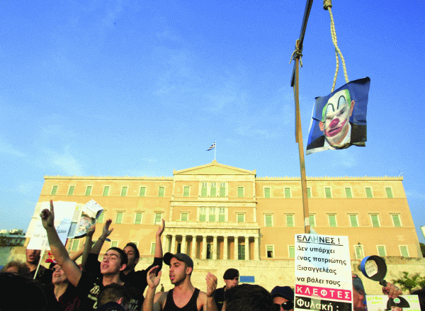 O fotografie a premierului Greciei, George Papandreou, în postura de clown spânzurat a fost agăţată, la finalul săptămânii trecute, în faţa Parlamentului de către protestatari. Aceştia au strigat: Nu sunt patrioţi aici. Legaţi-i!