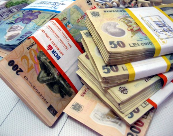 Analiştii financiari estimează o depreciere a leului şi o majorare a primei de risc a României